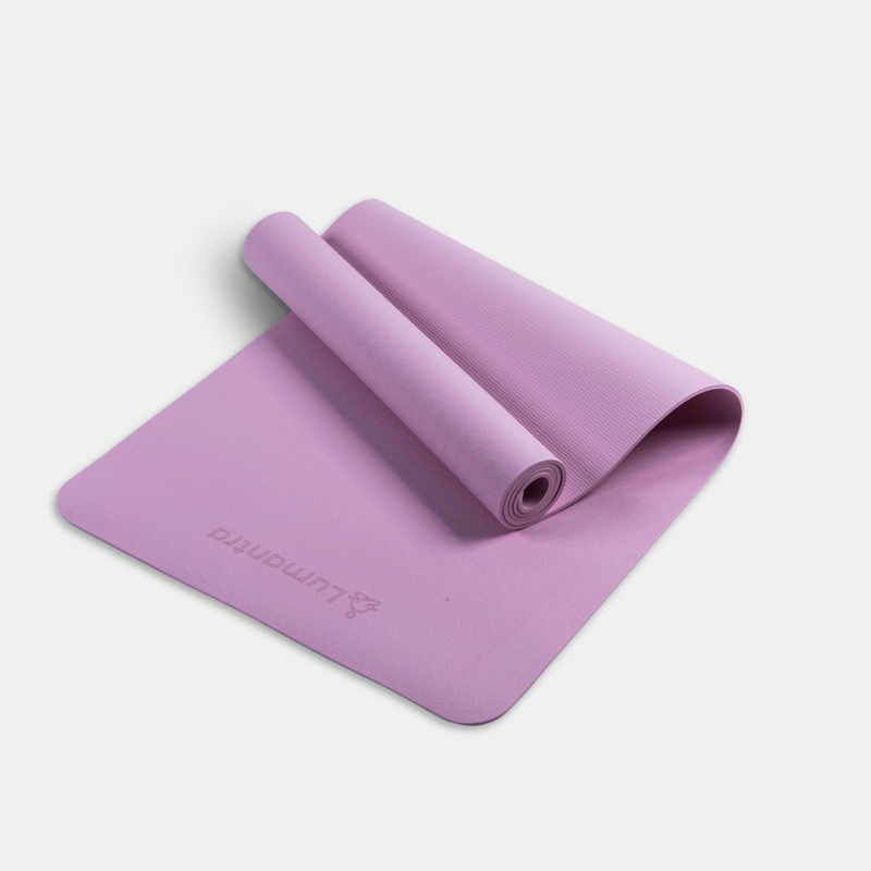 Pink Lumantra yoga mat rolled partially open, showcasing its eco-friendly texture and non-slip surface.