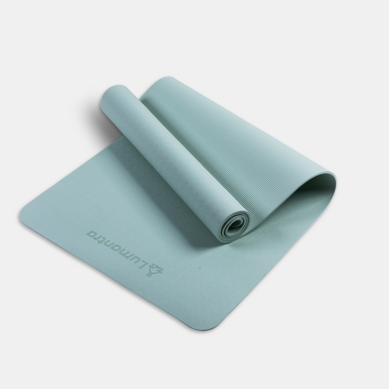 Green Lumantra yoga mat rolled partially open, showcasing its eco-friendly texture and non-slip surface.