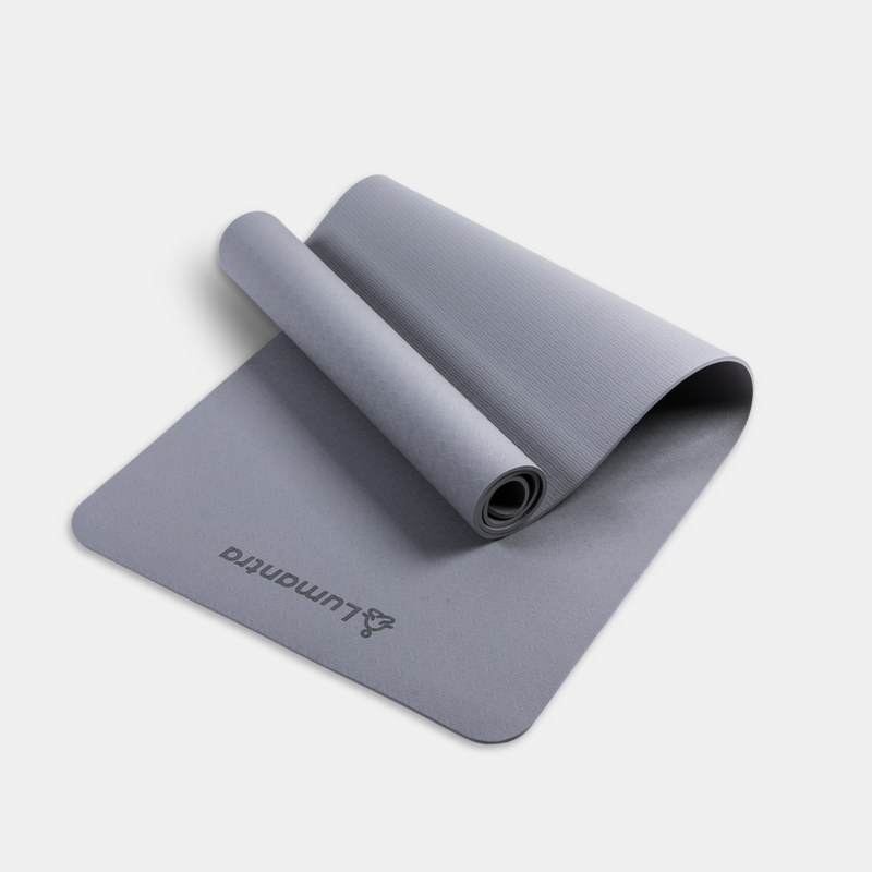 Grey Lumantra yoga mat rolled partially open, showcasing its eco-friendly texture and non-slip surface.